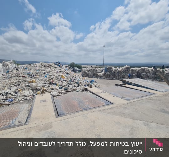 ערימת פסולת באתר מיחזור תחת שמיים כחולים
